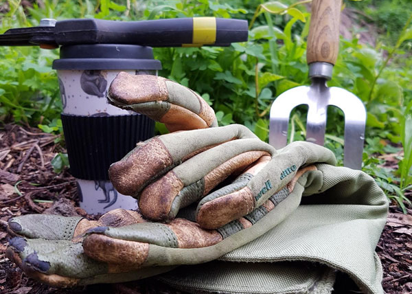 Coffe cup with weeding tools and gloves